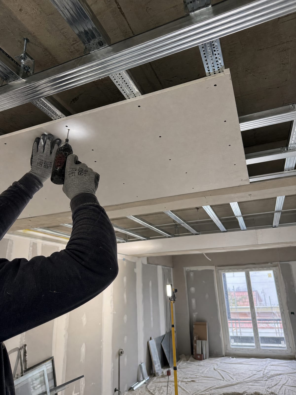 Plaster ceiling installation in progress, showing gypsum board framing and metal furring channels