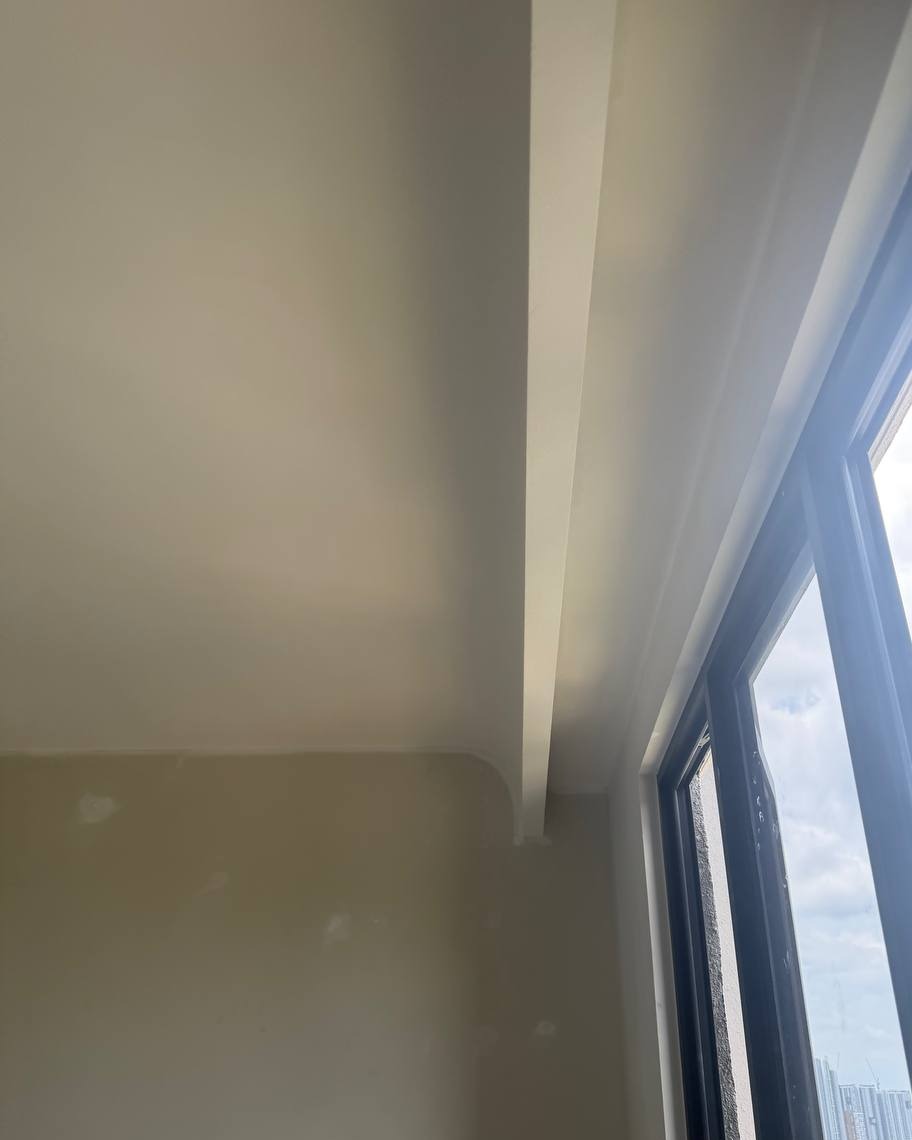 Curved plaster ceiling edge with smooth cove transition beside floor-to-ceiling window in Bangsar residential unit