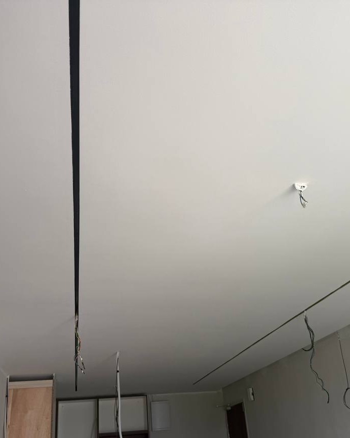 Freshly plastered ceiling in Bangsar residential project with recessed shadow-gap line and exposed wiring for pendant light and downlight, ready for electrical fitting