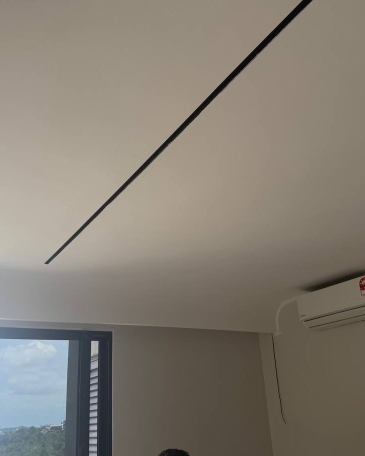 Cracked plaster ceiling seam near curved bulkhead corner above window and air conditioner unit in Bangsar residential ceiling project
