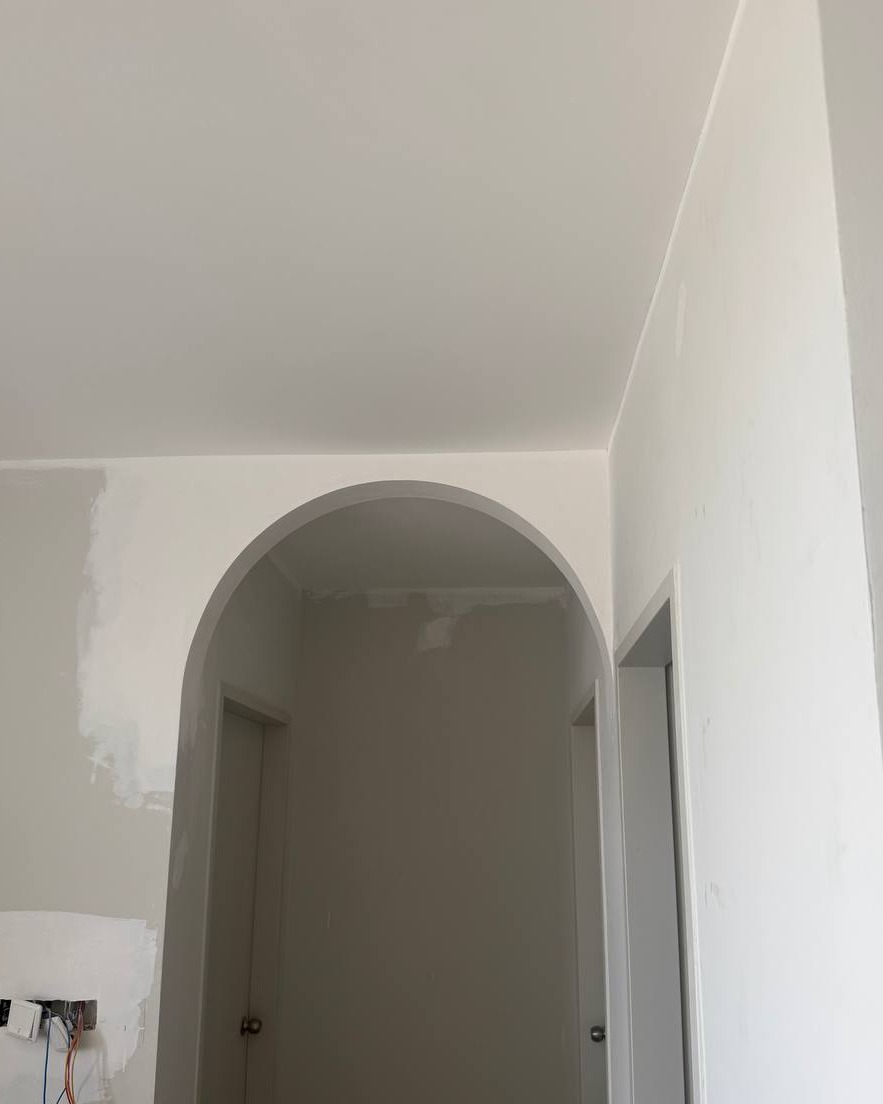 Curved plaster archway leading to hallway with smooth flat ceiling finish, Bangsar residential ceiling design project