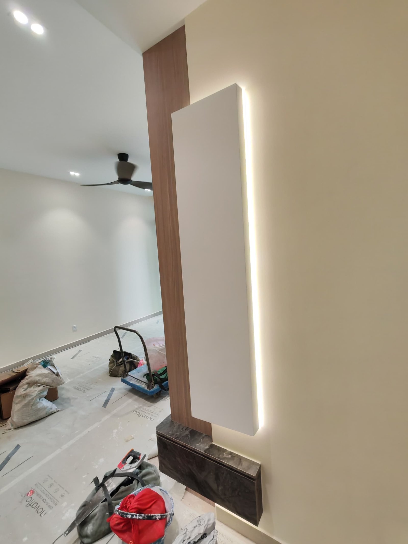 Backlit Vertical Feature Panel – Sungai Long Living Room Tall backlit vertical feature panel with LED edge lighting against wood-tone wall and dark marble-effect base, Sungai Long living room