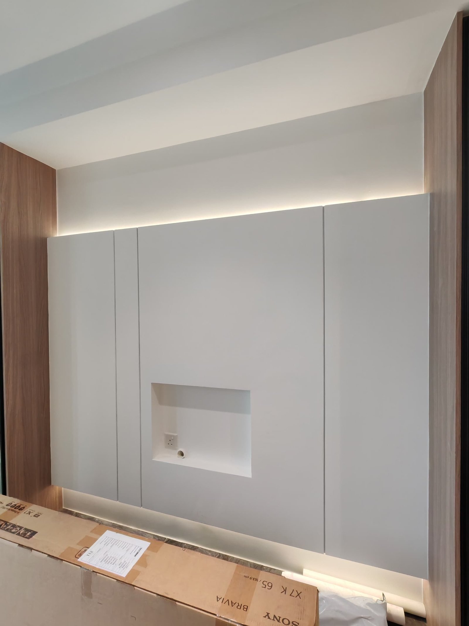 TV Feature Wall with Recessed Niche and LED Cove Custom gypsum TV feature wall with recessed wall-mount niche and LED cove lighting along the top edge, Sungai Long renovation