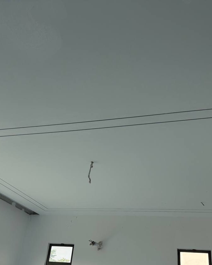 Cove Ceiling Groove with Exposed Wiring - Cyberjaya Freshly skim-coated plaster ceiling with recessed cove lighting groove and pending electrical wiring at Cyberjaya residential staircase project