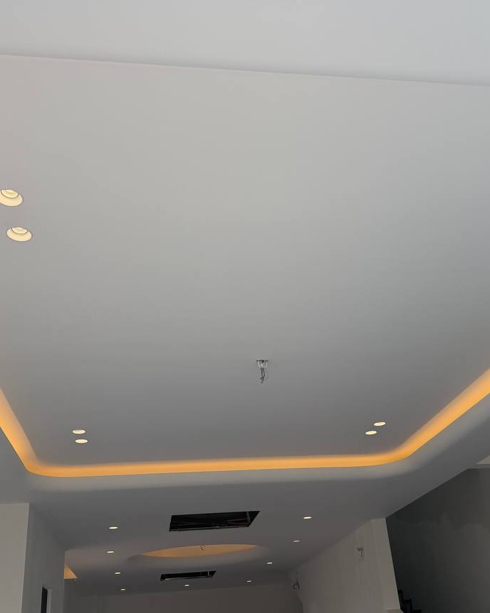 Multi-level plaster ceiling with recessed downlights and warm cove lighting trough, Klang residence