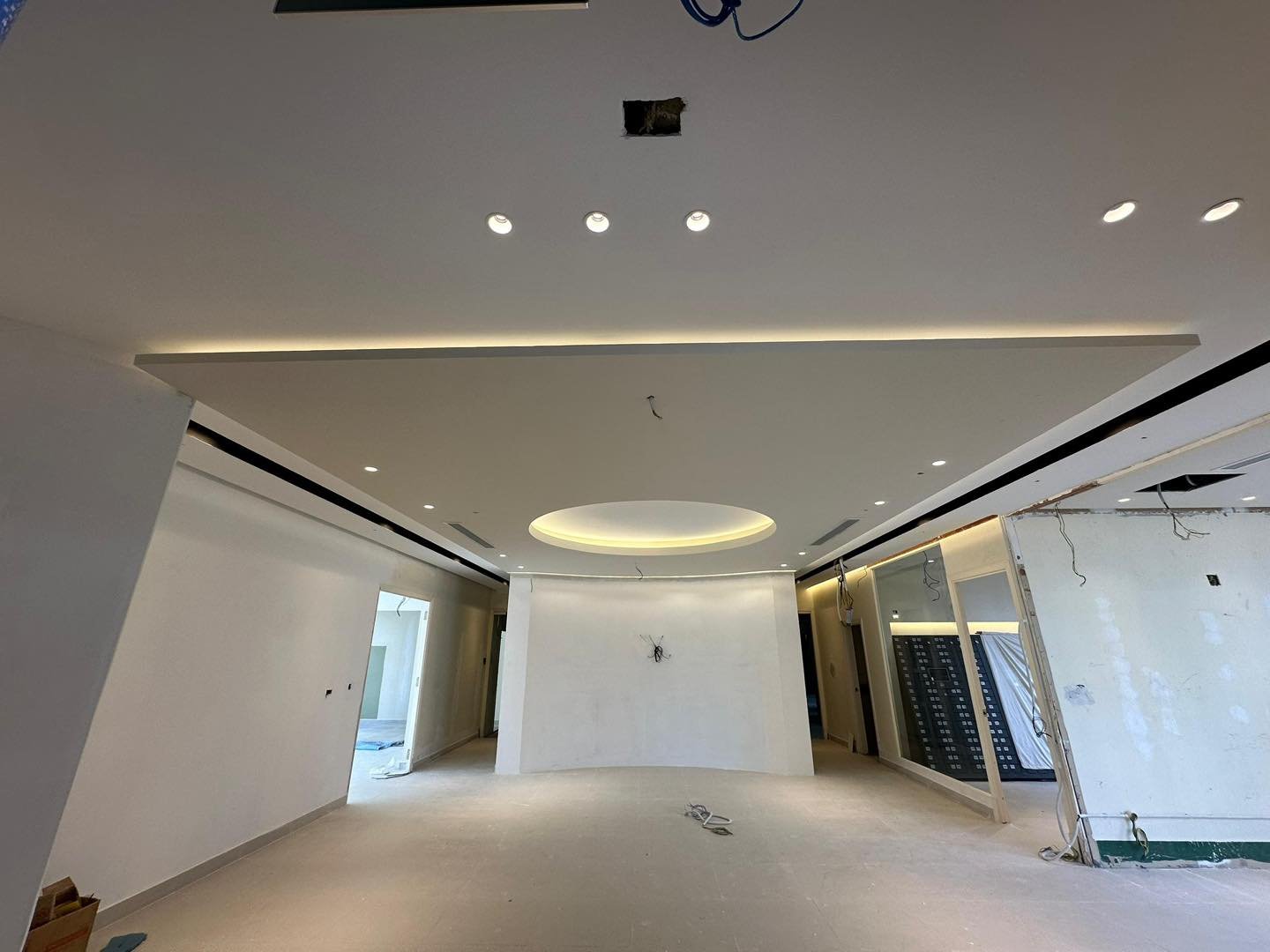 Living & Dining Ceiling with Floating Moon Centrepiece - KL Wide view of open-plan living and dining area plaster ceiling with cove lighting perimeter leading to circular floating moon ceiling centrepiece and curved partition wall, Kuala Lumpur bungalow renovation