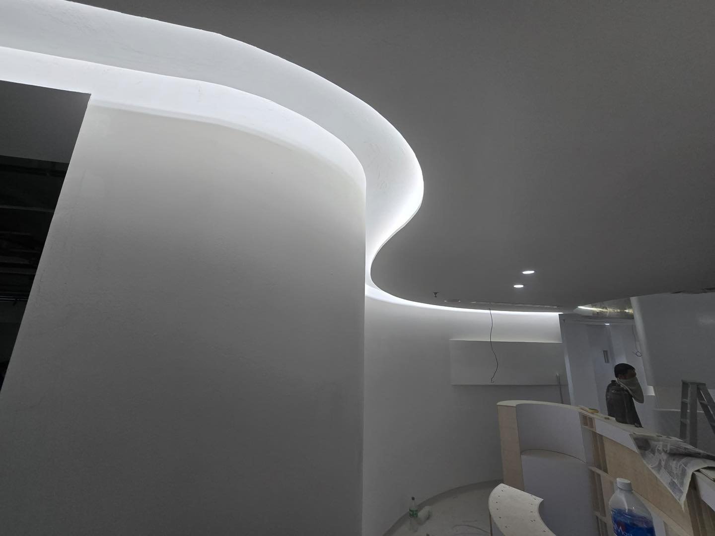 Ceiling-to-Wall Curve Detail with LED Cove – Mid Valley Close-up of curved plaster ceiling-to-wall junction with recessed linear LED cove lighting, Mid Valley beauty salon interior
