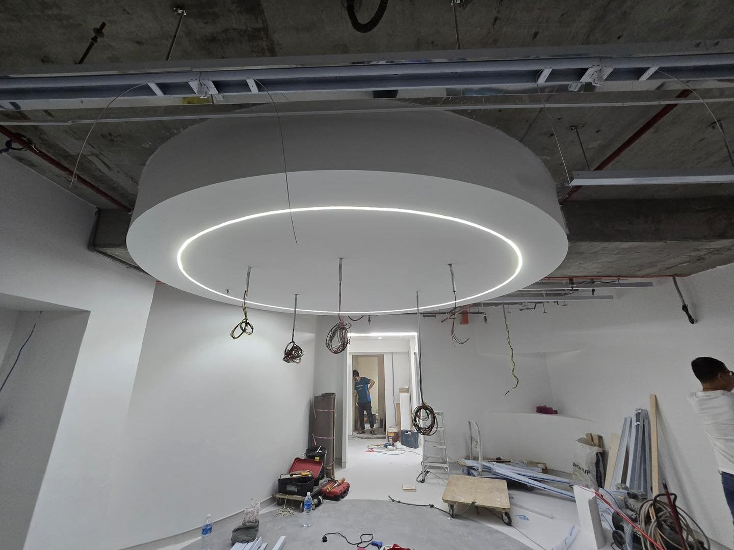 Circular Suspended Ceiling Feature with LED Ring Circular suspended plaster ceiling feature with recessed ring LED light hanging below exposed services, Mid Valley salon fit-out
