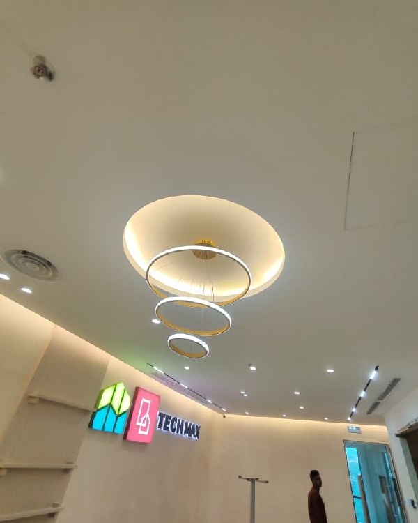 Circular plaster ceiling drop with concealed LED cove lighting and tiered round pendant chandelier above Tech Max office reception, Old Klang Road Kuala Lumpur