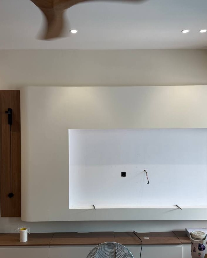 Curved plaster feature wall with recessed LED cove lighting above TV console area, plaster ceiling with downlights in Rawang residential ground floor renovation