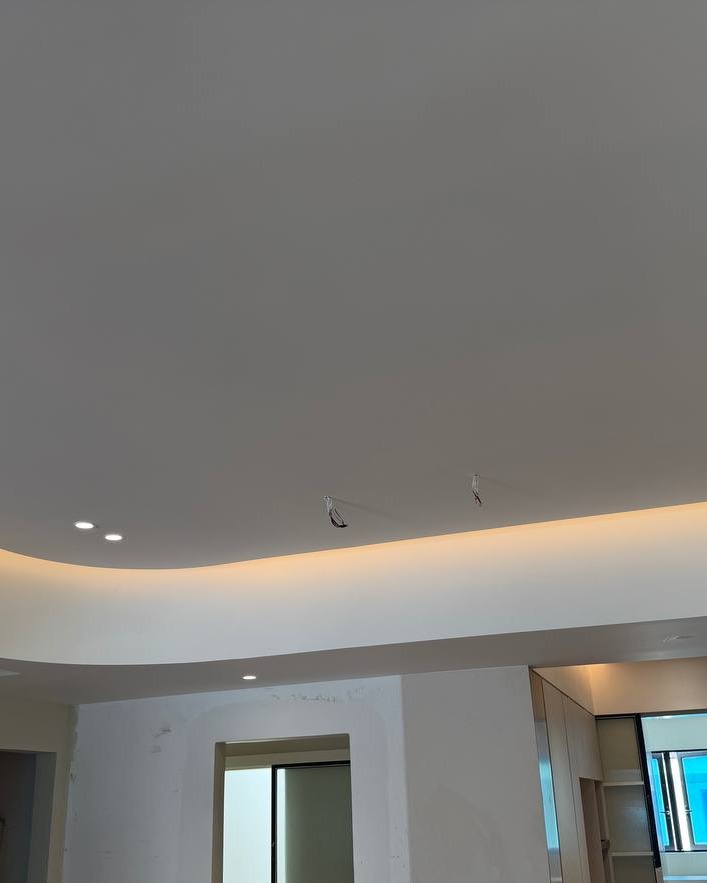 Curved plaster ceiling with hidden cove lighting and recessed downlights above open living space, Rawang residential ground floor
