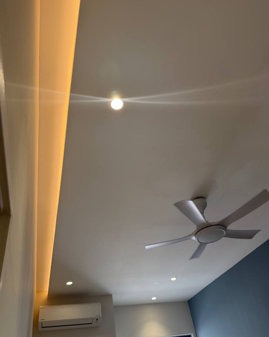 Curved plaster ceiling drop with warm LED strip lighting, recessed downlights, spotlight, and ceiling fan in Rawang residential home