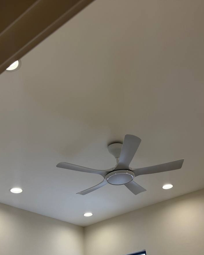 Sloped white plaster ceiling in Rawang home with five-blade ceiling fan and recessed LED downlights