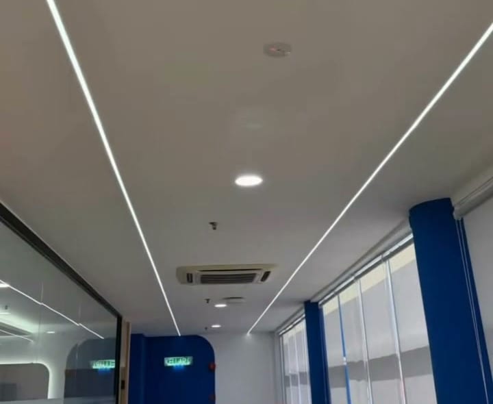 Office corridor ceiling with long recessed LED profile lines and downlights, Shah Alam