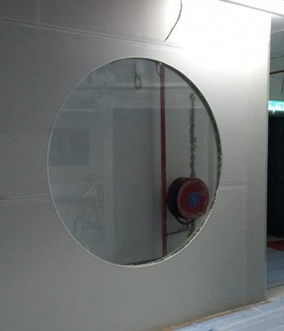 Round Glass Window – Shah Alam Close view of the round clear-glass window set into a drywall partition, Shah Alam