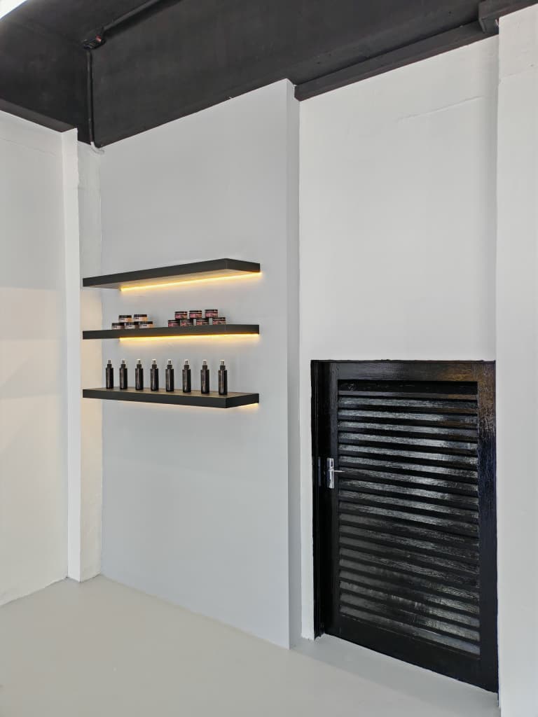 LED-lit product display shelving Barberroom by Jiro fit-out — LED-lit product display shelving beside a grooming room door