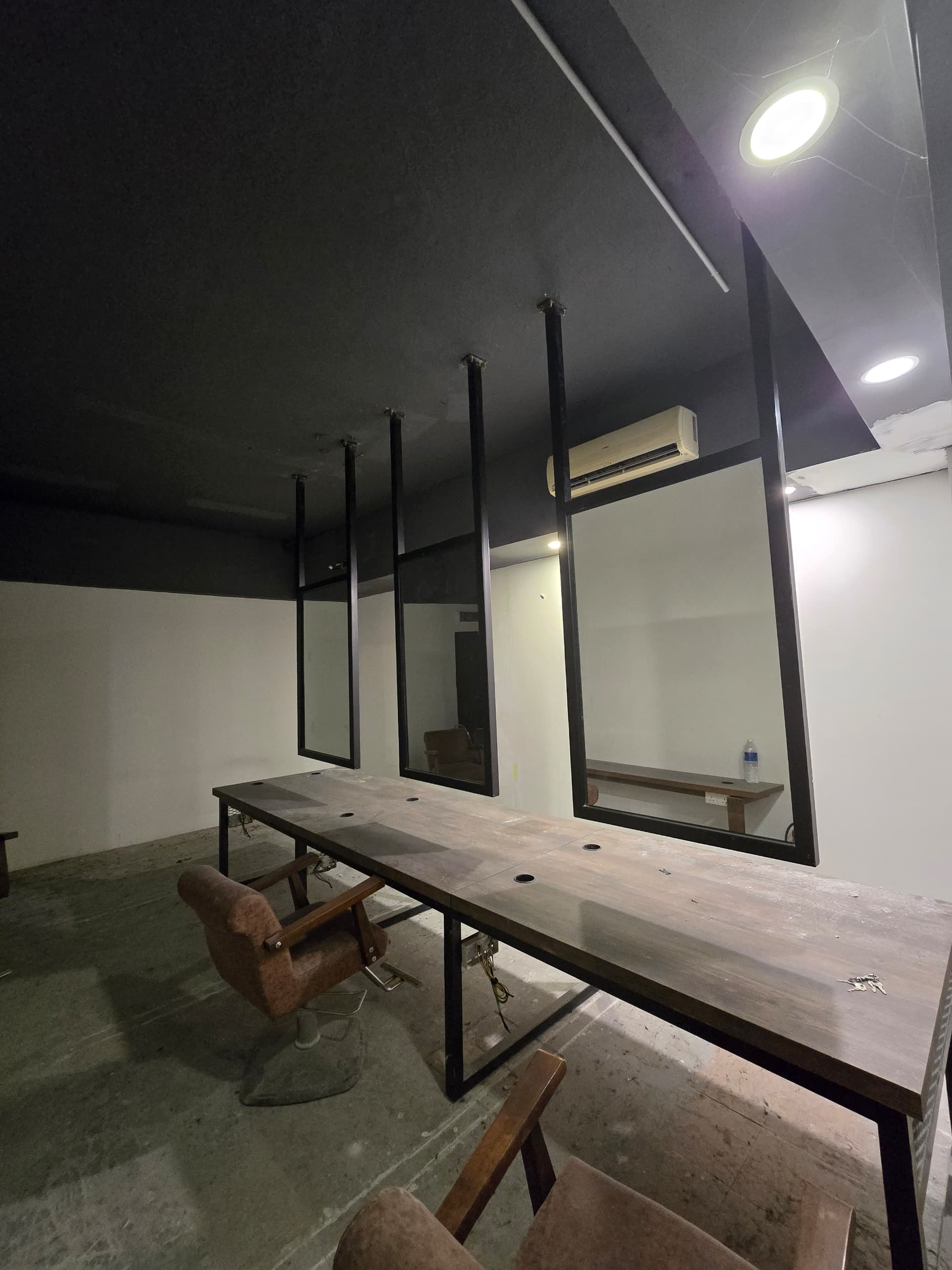 Black plaster ceiling above styling stations Barberroom by Jiro fit-out — black plaster ceiling with styling stations and hanging mirrors